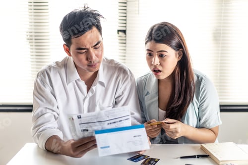 Preview: Asian young man and woman try to find money to pay credit card debt and all loan bills.
