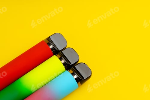 Preview: Colorful disposable electronic cigarettes on yellow background