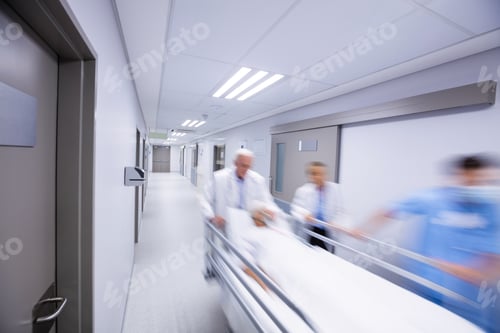 Preview: Doctors and nurse pushing emergency stretcher bed in corridor
