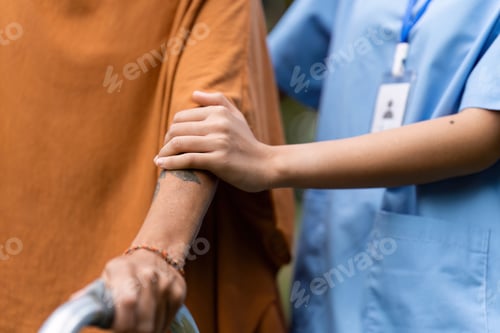 Preview: Nurse or caregiver help elderly walk by using walker in garden