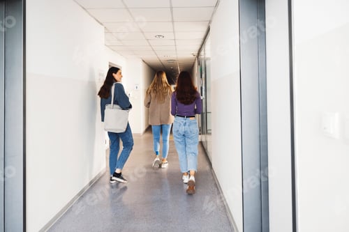 Preview: View from the back three friends walking in the hallway, searching for their classroom