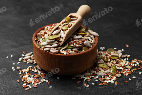 Preview: Mix of seeds and scoop in bowl on black textured table, closeup