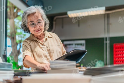 Preview: Senior Female Business Owner Inspecting Ceramics