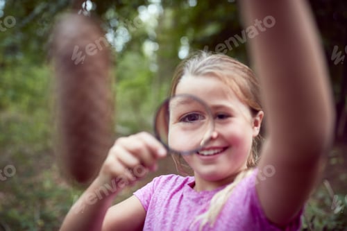 Preview: Girl At Outdoor Activity Camp Studying Pine Cone With Magnifying Glass