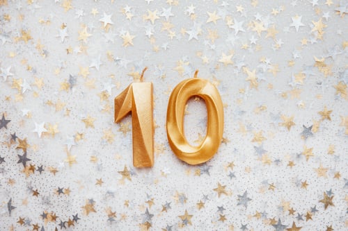 Preview: Number 10 ten golden celebration birthday candle on Festive Background.