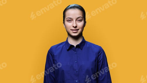 Preview: Portrait of smiling teenage girl 15, 16 years old on yellow background