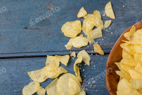 Preview: Directly above shot of potato chips with salt on wooden table