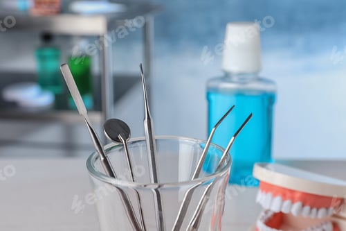 Preview: Glass with different dentist tools in lab, closeup