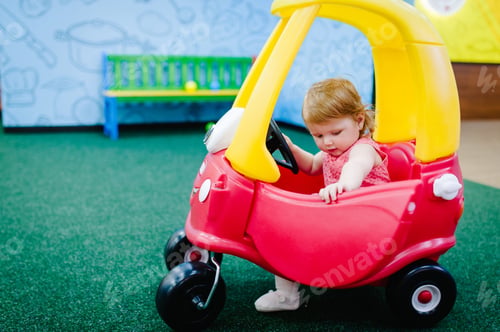 Preview: Happy children, little girl child rides on a red big car on the road. Close up. The baby is driving