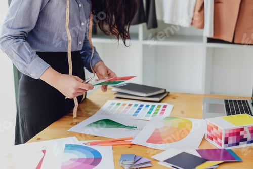Preview: Young asian woman fashion designer working on her designs in the studio.