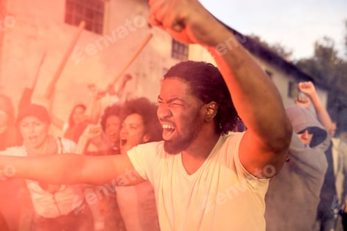 Preview: Rebellious black man with crowd of people participating in public demonstrations.