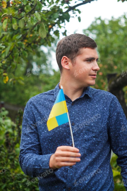 Preview: Ukrainian man. Young man holding ukrainian flag. No war. Support for Ukraine. Patriotic Spirit risin