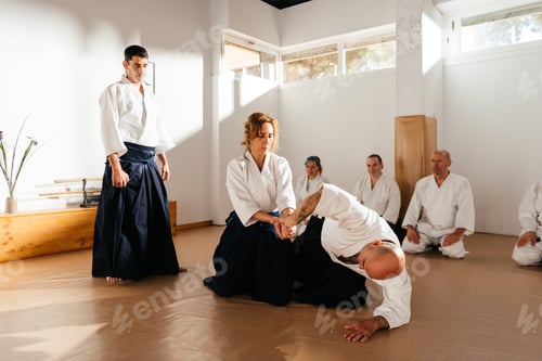 Preview: Martial Arts Instructor Supervises Female Students Wrist Lock Technique During Dojo Practice Session
