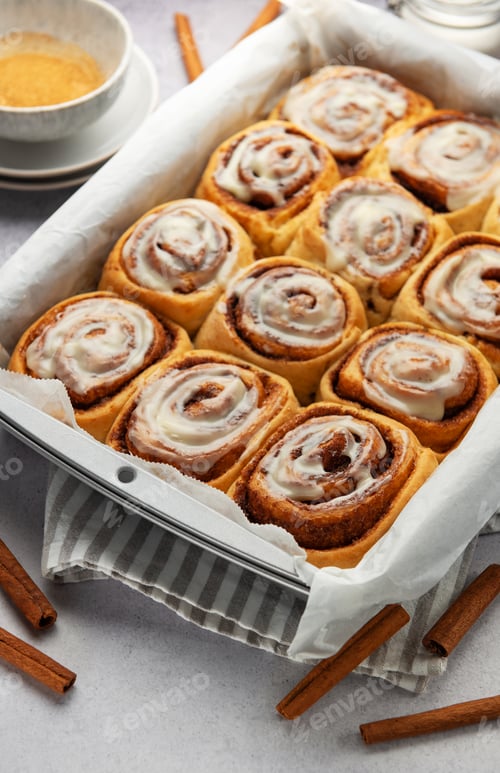 Preview: Freshly baked cinnamon rolls drizzled with icing in a baking pan
