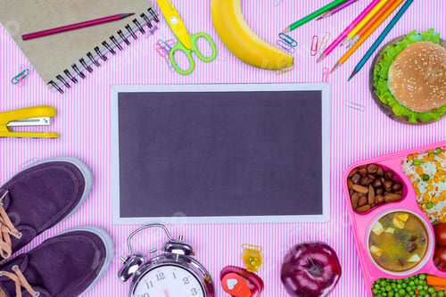 Preview: top view of blackboard and tray with kids lunch for school on violet surface
