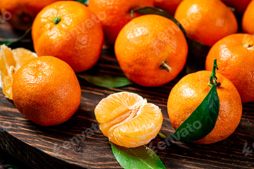 Preview: Juicy tangerines with leaves on a wooden tray.