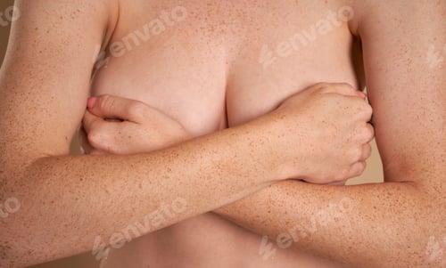 Preview: Unrecognizable naked woman covering her breast with hands