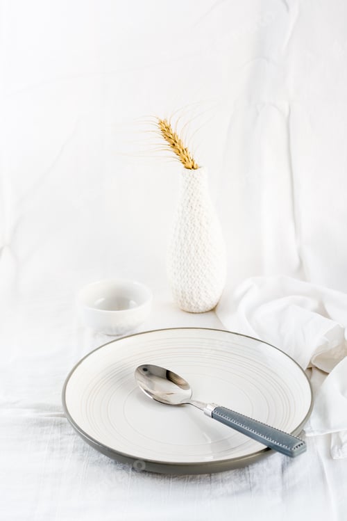 Preview: Home serving dishes for eating. Empty plate and spoon on the table on a white cloth. Vertical view