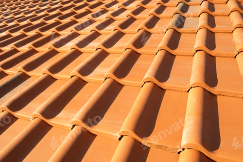 Preview: Overlapping rows of yellow ceramic roofing tiles covering residential building roof.