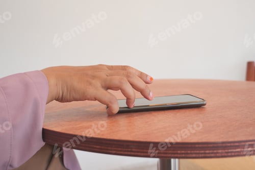 Preview: man hand picking up smart phone mobile to receive a call