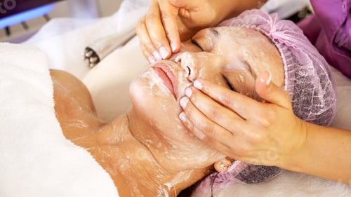 Preview: Cosmetologist applies a moisturizing mask on female face.