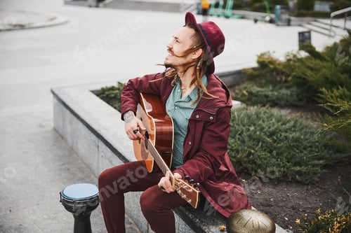Preview: Young Man Plays Guitar in the City Outdoors