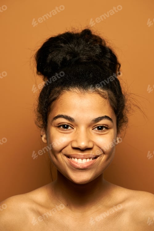 Preview: Smiling Woman with Hair Updo Against Brown Backdrop