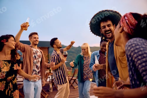 Visualização: Homem feliz e seus amigos se divertindo durante a festa de verão no terraço ao pôr do sol.