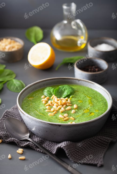 Preview: green creamy cauliflower spinach soup on gray background