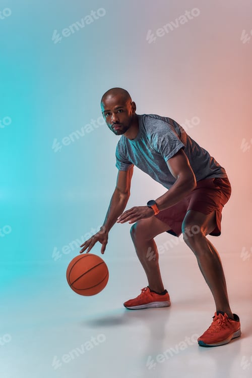 Preview: Ready to win. Full length of confident young african man in sports clothing playing basketball while