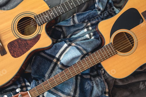 Preview: Two acoustic guitars on a cozy plaid, top view.