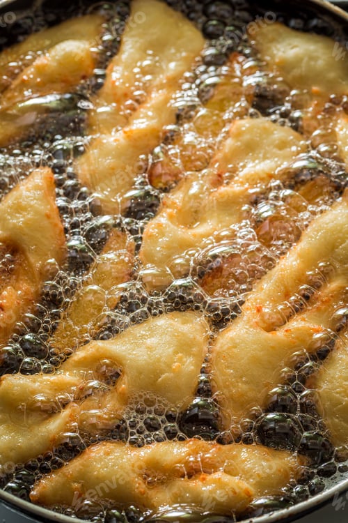 Preview: Frying angel wings on hot oil. Donuts for Fat Thursday.