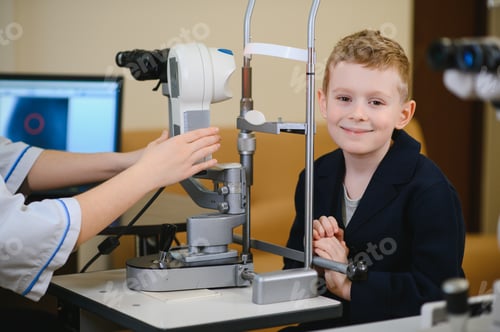 Preview: Ophthalmologist preparing vision diagnostics equipment for child in clinic