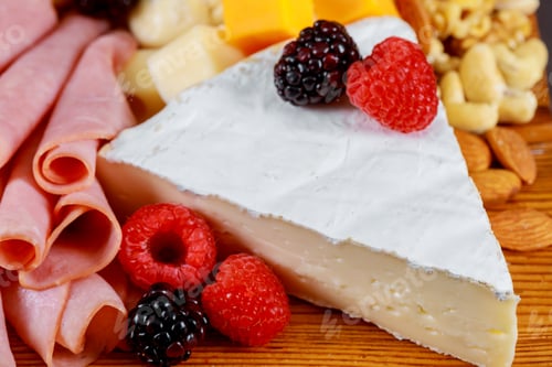 Preview: Beautiful collection set decor, nuts and berries on fresh assorted cheese, top view composition