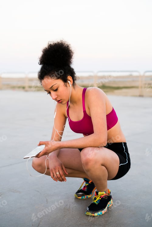 Visualização: Jovem corredor com fones de ouvido e telefone celular