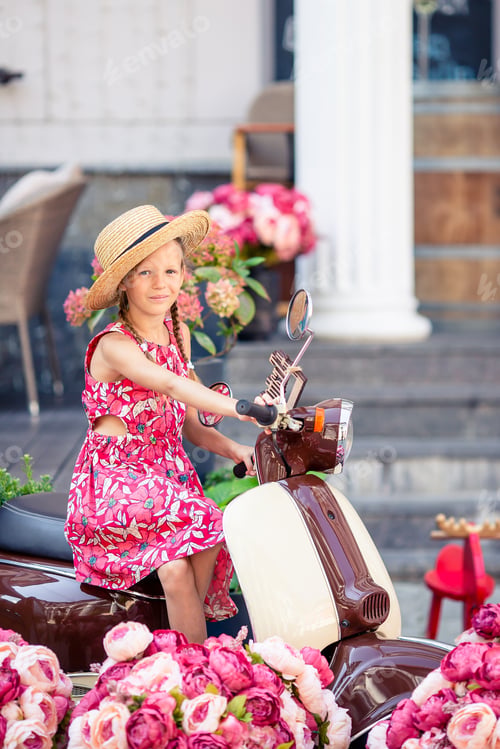 Preview: Adorable little girl in hat on the moped outdoors