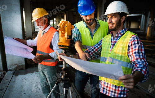 Preview: Two satisfied engineers talking at building site with construction structure in background