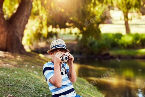 Preview: Shot of a little boy taking a photo with a vintage camera at the park