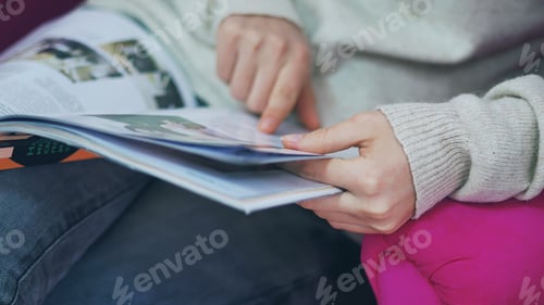 Preview: Woman reading fashion magazine closeup