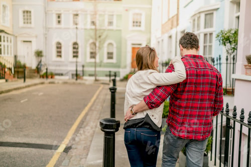 Preview: Rear view of young couple strolling on Kings Road, London, UK