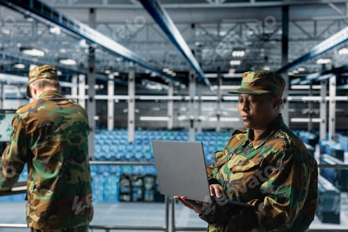 Preview: Woman in server room command center managing military operations using laptop
