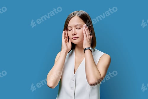 Preview: Young woman experiencing stress headache, on blue background