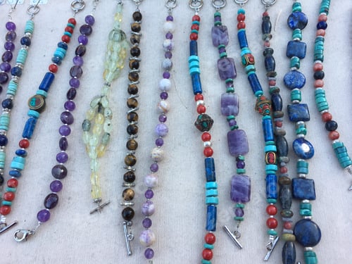 Preview: Handmade bracelets made with semi precious stones and beads, displayed on a market stall
