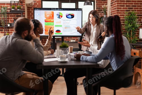 Preview: Businesswoman standing in front on monitor explaining management statistics