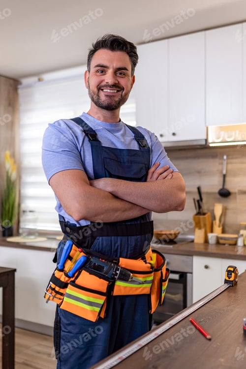 Preview: Worker in a kitchen smiling with tools in a busy home renovation setting