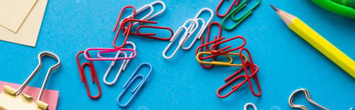 Preview: close up view of colorful paper clips near pencil on blue, banner
