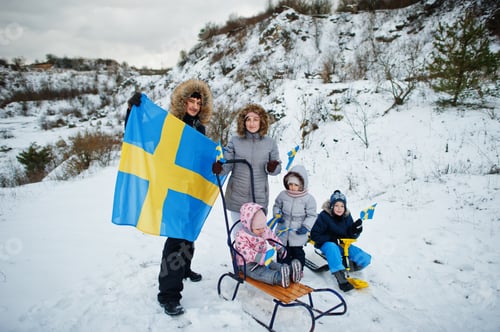 Preview: Scandinavian family with Sweden flag in winter swedish landscape.