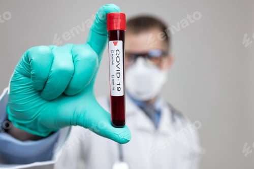 Preview: Doctor wearing respiratory mask and holding the Coronavirus blood sample