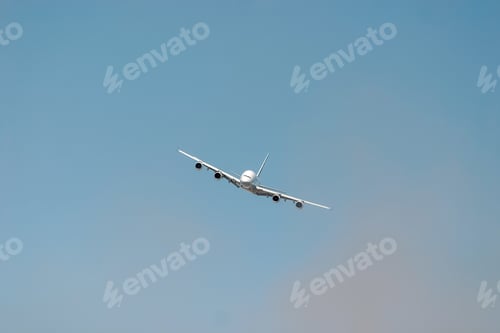 Preview: Large passenger plane is flying high in the sky, leaving a trail of white smoke behind it.