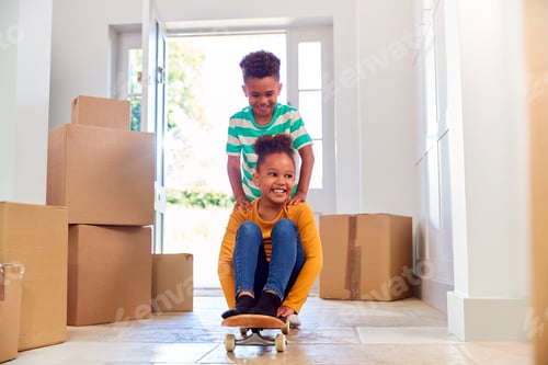 Preview: Two Children With Boxes On Moving In Day Playing On Skateboard